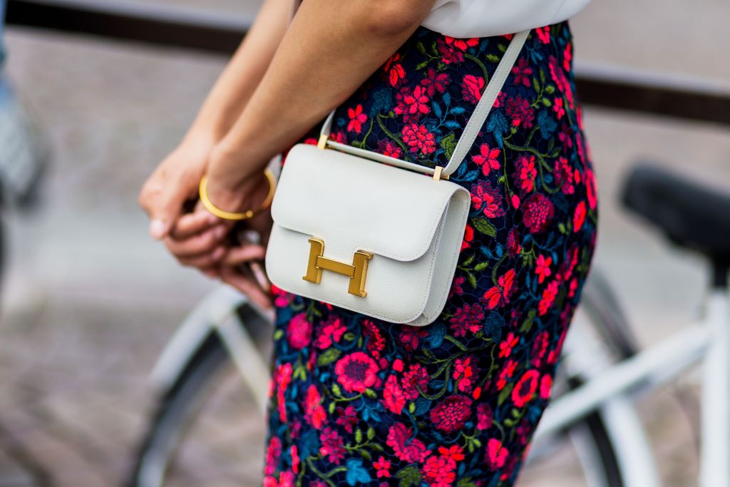 Three classic Hermès handbags—Birkin, Kelly, and Constance—arranged elegantly to highlight their timeless style and details