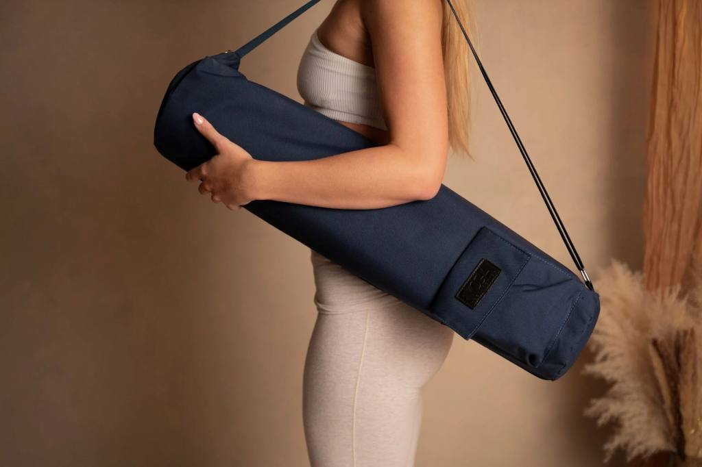 Woman smiling carrying Gonex Canvas Yoga Mat Bag with adjustable shoulder strap over shoulder at park