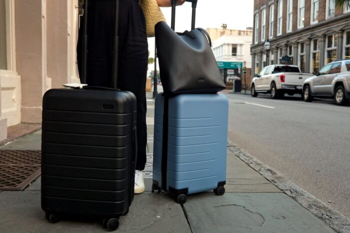 Traveler rolling stylish carry-on luggage through airport for smooth travel